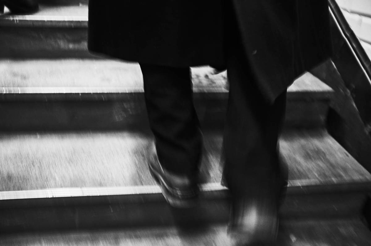 The blurry silhouette of a man climbing stairs in a subway corridor, from the series Going Underground by Emmanuel Pineau